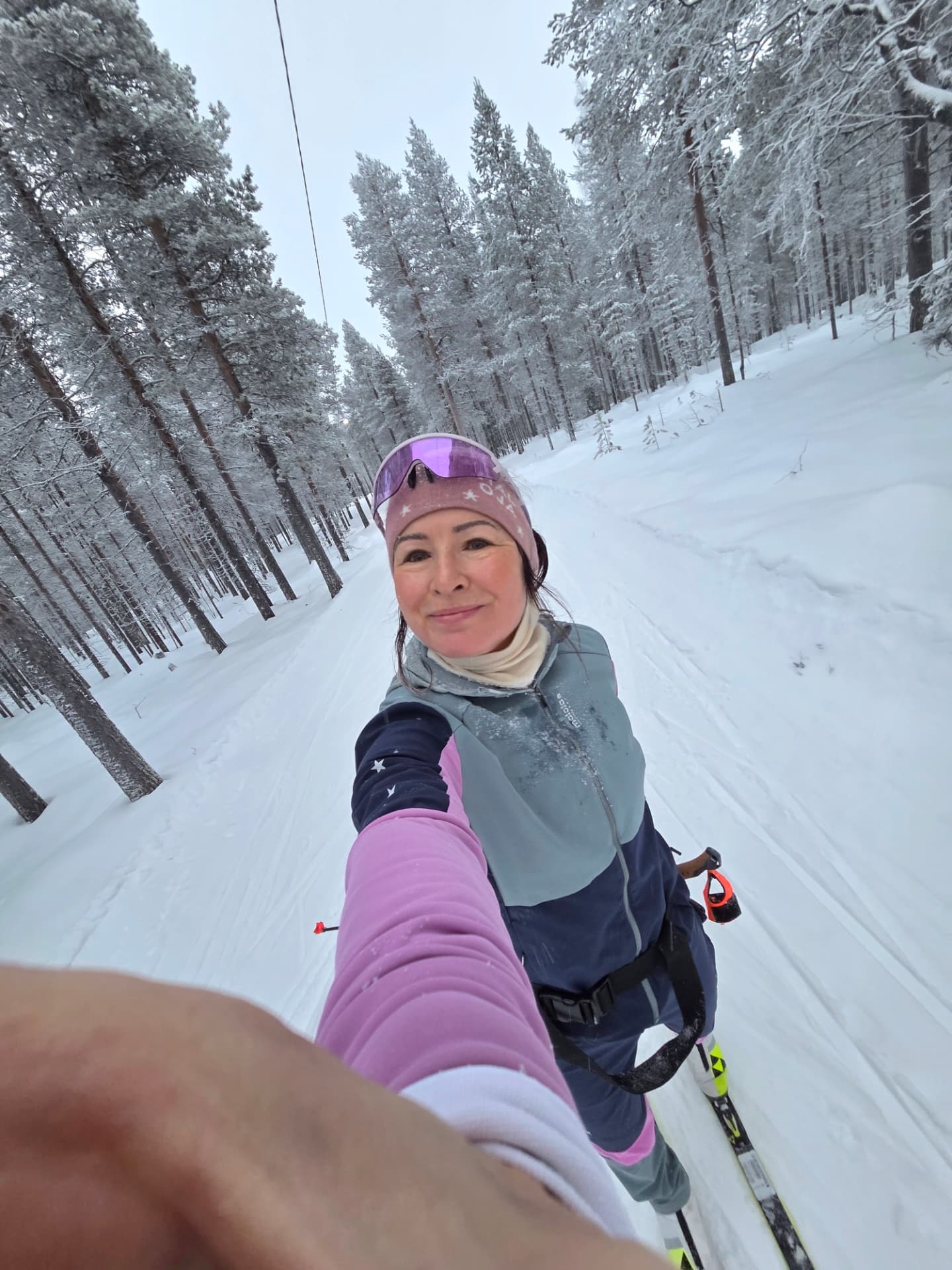 Riitta-Liisa Lassila taking a selfie while cross-country skiing in a snowy forest